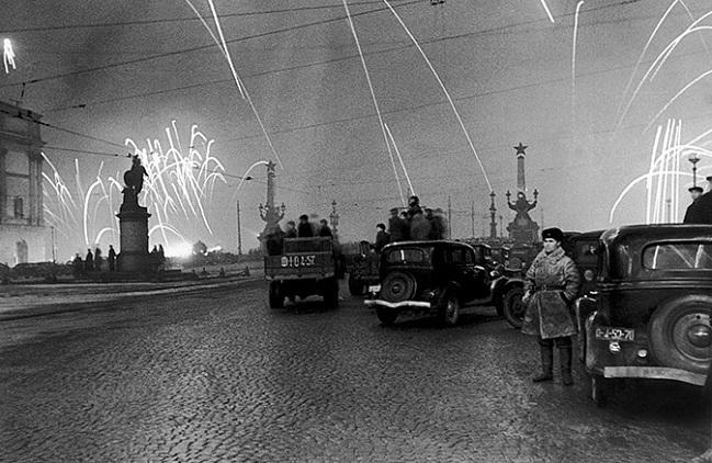 Ленинградцы на Суворовской площади смотрят салют в ознаменование снятия блокады. 27 января 1944 года