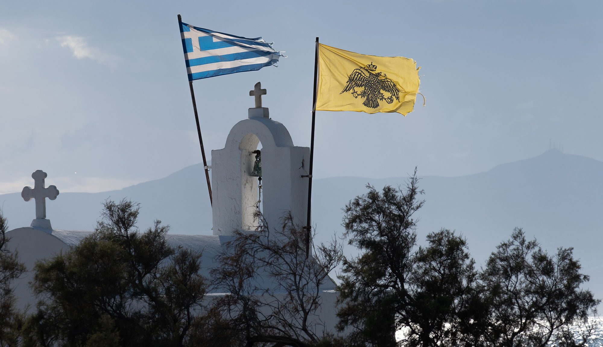 Греческий и византийский флаги над часовней в городе Наксос. Фото: РИА Новости/Иван Секретарёв