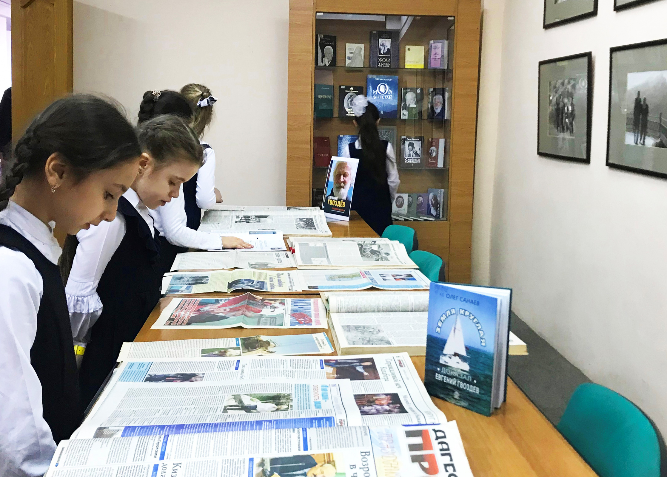 У стенда с газетными статьями и книгами о кругосветных плаваниях Евгения Гвоздёва. Фото предоставлено Дагестанским отделением РГО.