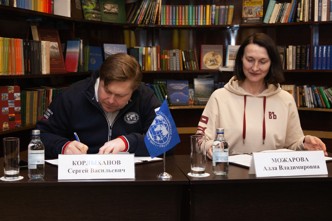 The official signing of the agreement. Sergei Korlykhanov, First Deputy Executive Director of the RGS, and Alla Mozharova, Head of Marketing and Public Relations at “Vodohod”. Photo: Anna Yurgenson / RGS press service 