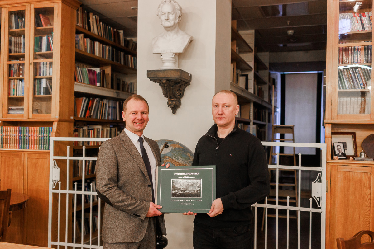 Роман Рябинцев, директор Штаб-квартиры РГО передает книгу Арсению Мухину для арктический станции "Прогресс". Фото: Ольга Семенова