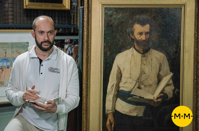 Nikolai Miklukho-Maklai next to the portrait of his famous ancestor by A. I. Korzukhin. Photo provided by the Miklukho-Maklai Foundation / mikluho-maclay.org