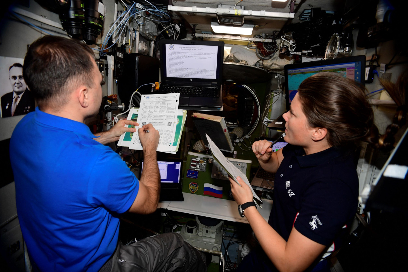 Космонавты Дмитрий Петелин и Анна Кикина ищут ответы на задания Географического диктанта. Фото: Роскосмос